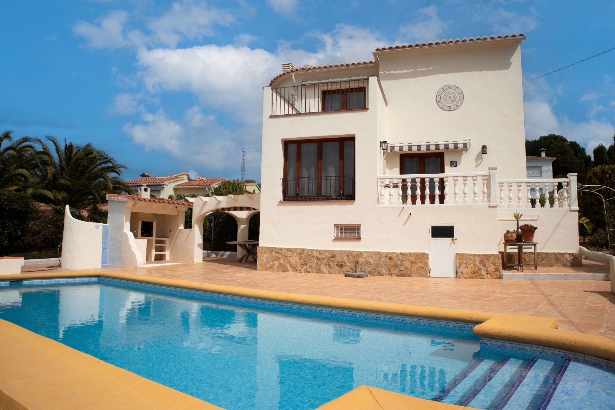 Villa met zwembad en balkons onder blauwe lucht